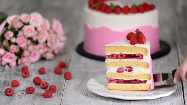 Piece of delicious raspberry cake with fresh raspberries.