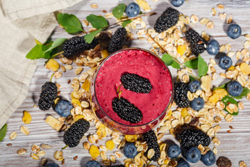 Glass of smoothies, muesli and fresh berries
