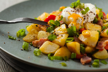Traditional American hash with fried eggs. Front view.