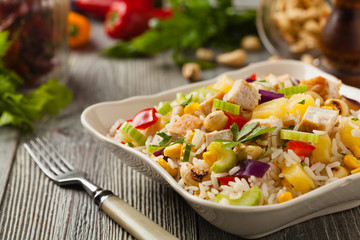 Salad with rice, chicken, peanuts and vegetables. Front view.