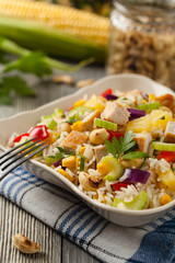 Salad with rice, chicken, peanuts and vegetables. Front view.