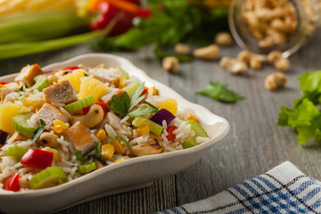 Salad with rice, chicken, peanuts and vegetables. Front view.