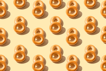 Bagels pattern on a peach color background . Bakery product template, traditional Russian bread product. Creative layout. Top view