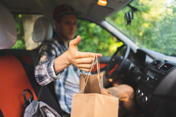 courier sit inside the car and move to the client to give the package