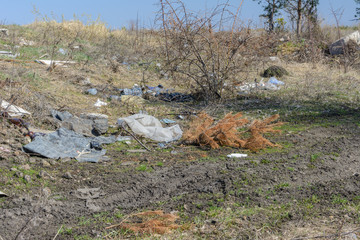 Environmental pollution. People left debris in wildlife. Garbage dump on the grass near the forest ...