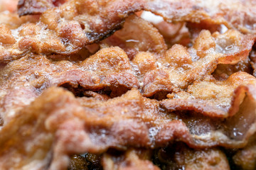 Cooked, appetizing bacon rashers on plate, closeup