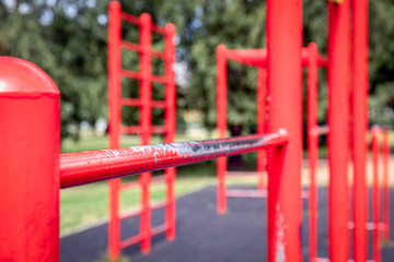Red gymnastic bars outdoors, open-air gym