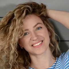 Naklejka premium Beautiful woman with a nice smile and long wavy hair. Close up portrait.