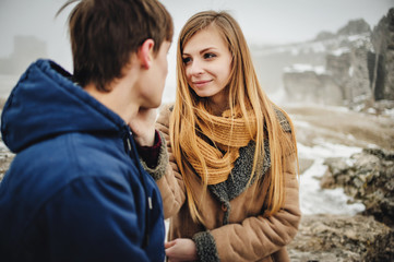 Fototapeta premium Two lovers are hugging in Saint Valentine's Day. Young romantic couple is having fun outdoors in winter park before Christmas. Enjoying spending time together in New Year Eve.