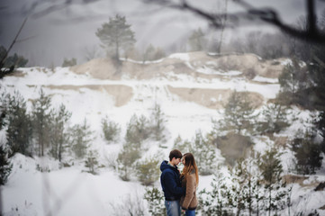 Love man and woman embracing outdoors winter snowfall. Happy holidays. Merry christmas and happy new year concept.