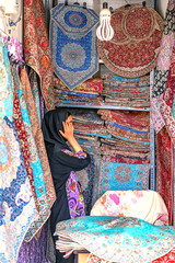 05/07/2019 Qom, Qom Province, Iran, selling handicraft tablecloths and handkerchiefs to a traditional Iranian pattern on the bazaar.