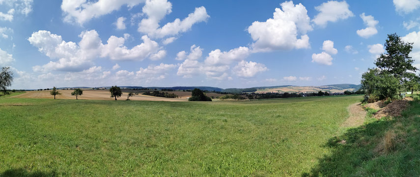 Landschaft und Felder mit Wolken am blauen Himmel