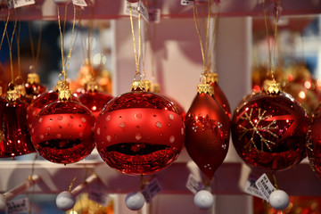 Red glass bulbs with golden glitter pattern. Fairytale Christmas tree ornaments closeup. Holiday decor. Christmas decorations. Christmas market in Berlin Germany. New Year celebration. Christmas mood.