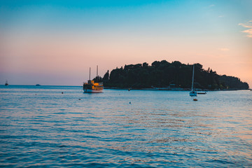 ship and yacht on sunset in sea bay summer time