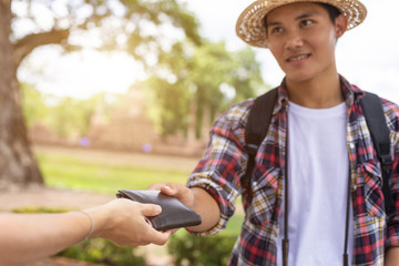 Asian tourist picking up his black wallet from other people that they found in tourist attraction