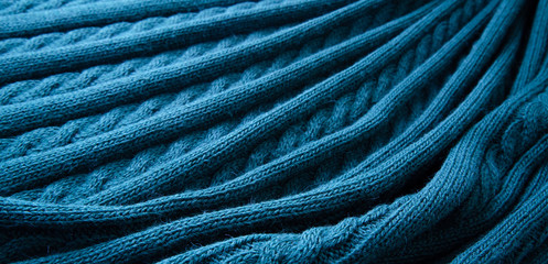 Blue plaid, knitted pigtail. Wool texture for background. Soft focus.