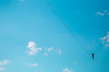 Highliner on the background of blue sky.