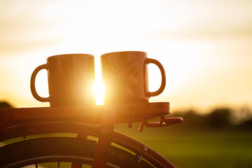 Coffee cup put on the Red Japan style classic bicycle at view of green rice field