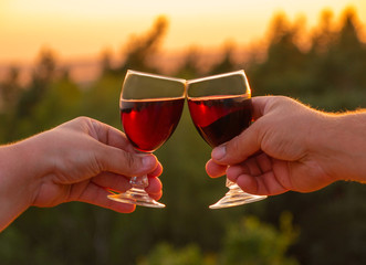 Mit einem Glas Wein beim Sonnenuntergang anstoßen