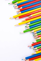 Many different colored pencils on a white background with a place for text and cory space .