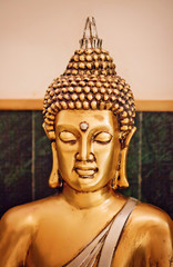 Close up yellow-gold statue Buddha in meditation.