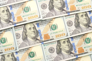 Background from banknotes of one hundred dollars lying on the diagonal. The view from the top.