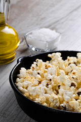  Prepared popcorn in frying pan, corn seeds in bowl and corncobs on kitchen table.Air salty popcorn. Salt popcorn on the wooden background . Chees .Popcorn texture