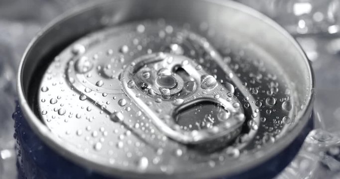 Aluminum soda can lid cover of soft drink and ice close-up rotation
