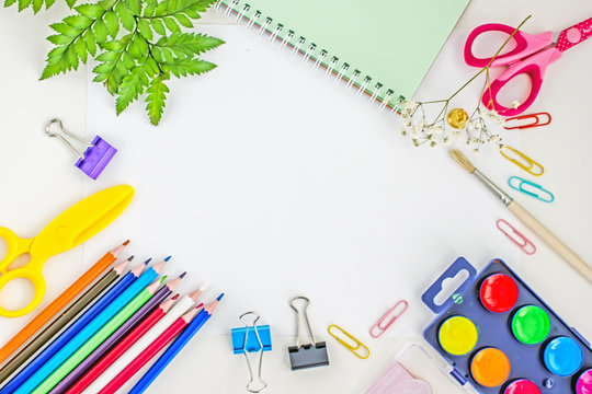 Education or back to school Concept. Top view of colorful school supplies with     paints, brush, scissors, notepad, color pencils, pen cutter clips  on  white background. Flat lay. Copy space, frame 