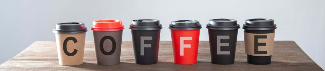 Word of coffee paper cup on on wooden table.