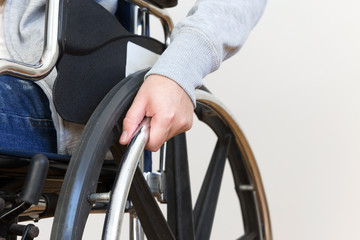 Obraz premium Szczegółowo niepełnosprawnej kobiety trzymającej rękę na kole wózka inwalidzkiego.