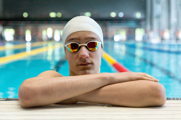 Portrait of a swimmer on the background of the pool.