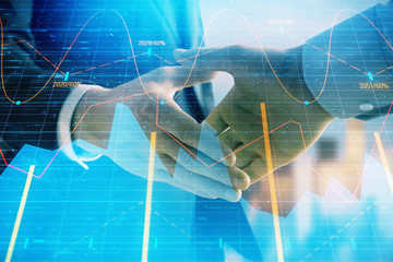 Fototapeta na wymiar Double exposure of financial graph on cityscape background with two businessman handshake. Concept of stock market deal
