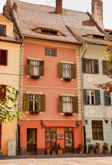 old building with open windows. flowers on windows.