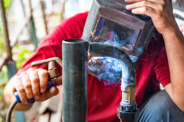 Worker cooks the heating pipe, welding joint. Preparing for winter heating.