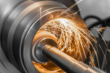 grinding metal on the machine, abrasive stone on the rim with sparks.