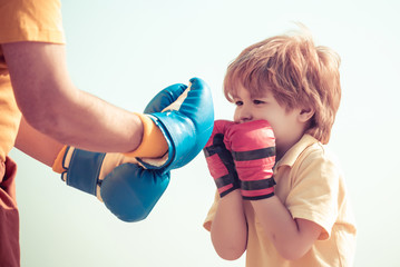 Senior trainer and little boy wearing boxing gloves. Portrait of a determined senior boxer with...