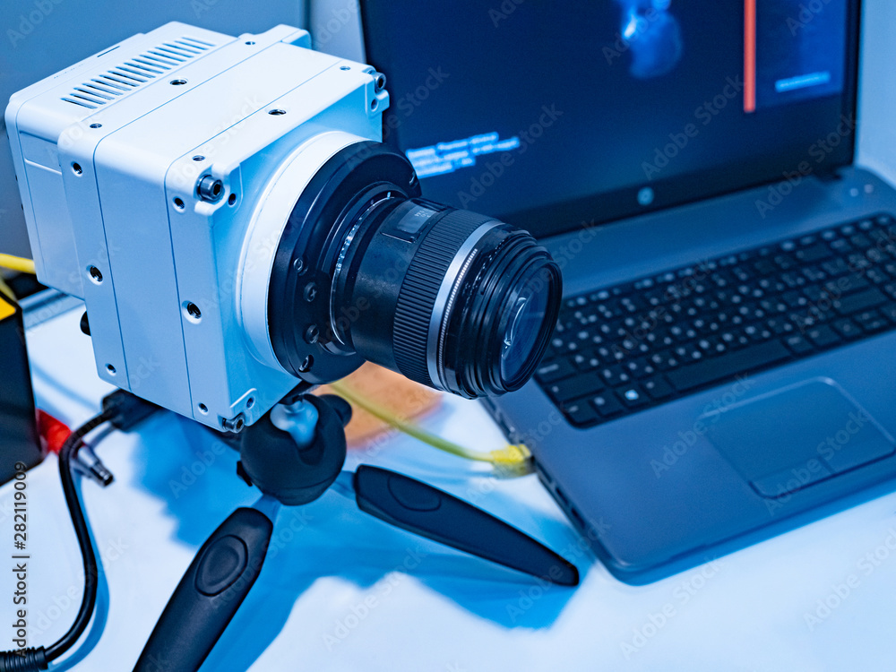 Poster the camera on the tripod and the computer on the desktop of the engineer. high-speed video camera. h