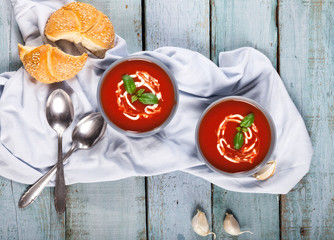 Traditional spanish cold tomato soup gazpacho in a bowl over blue wooden background.