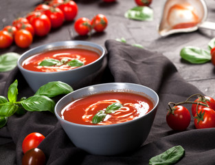 Traditional spanish cold tomato soup gazpacho in a bowl over black stone background.