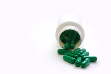 Medicine green  pills or capsules and aluminum foil blister on  white background with copy space. ...