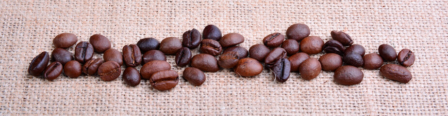 Heap of roasted coffee grains on jute burlap