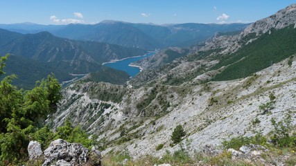 Amazing nature landscape in a National park with a Lake and green forest and desert grey mountains. Blue River and canyon. Mavrovo in Macedonia. Summer sunny day