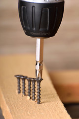 Close up Electric drill on wooden table background and copy space.  Hammer drill or screwdriver, Electric cordless hand drill on wooden. maintenance home concept. Screwdriver on a wooden background wi