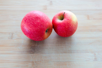 Zwei rote Äpfel auf einem Holzbrett