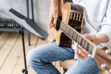 European male posing with acoustic guitar in his hands