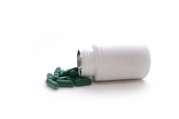 Medicine green  pills or capsules and aluminum foil blister on  white background with copy space. ...