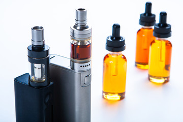 Vape concept. Vaping mod e-cig with tank atomizer and juice bottles. vaping device