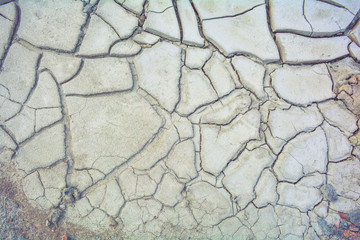 Dry mud ground, crack texture, granite gravel. Dry dirty soil. Cracks on clay