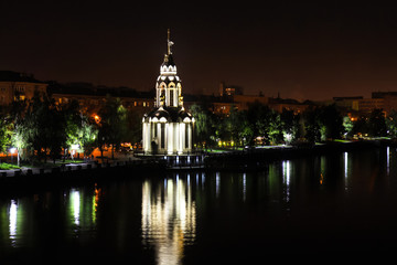 Night city landscape . Beautiful church with illuminating at night, lights reflected in the water....